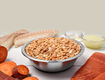 a custom just food for dogs recipe with cod, salmon, and sweet potato presented in a bowl with raw, fresh ingredients displayed around the bowl