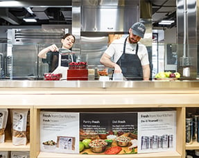 JustFoodForDogs Union Square NY Kitchen, located inside Petco. Interview view including two employees cooking. 