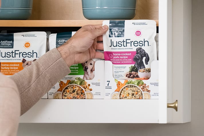person reaching for just fresh shelf-stable dog food from the cabinet